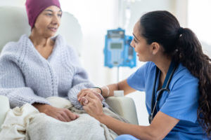Nurse talking with an oncology patient during palliative care at home.