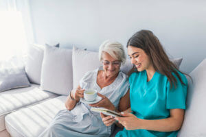 Home health care services professional providing companionship and support to senior woman at home
