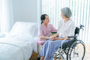 Senior woman and young caregiver during an hospice care at home.