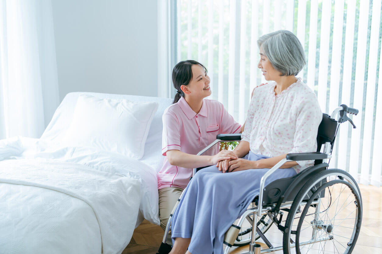 Senior woman and young caregiver during an hospice care at home.