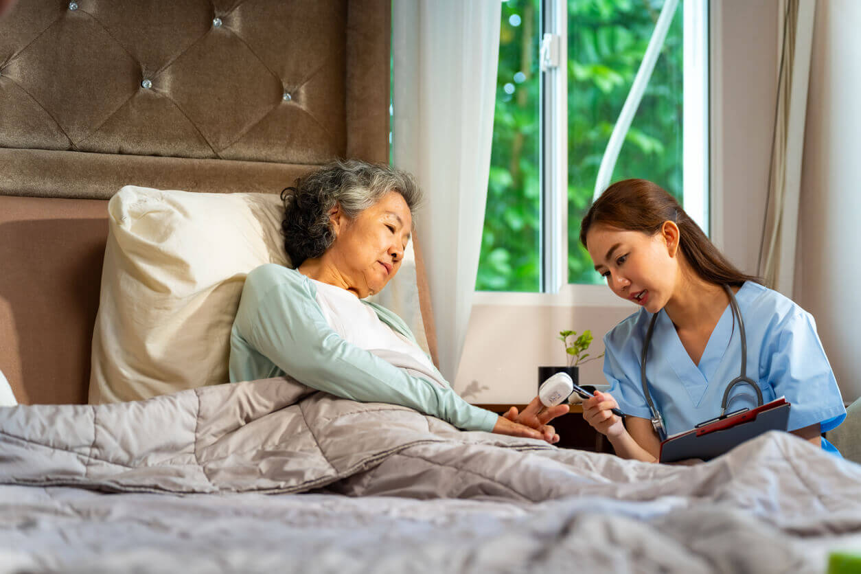 A private nurse examines a senior patient at home.