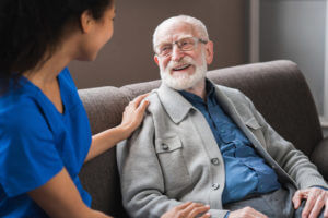 Picture of smiling nurse assisting senior elderly man